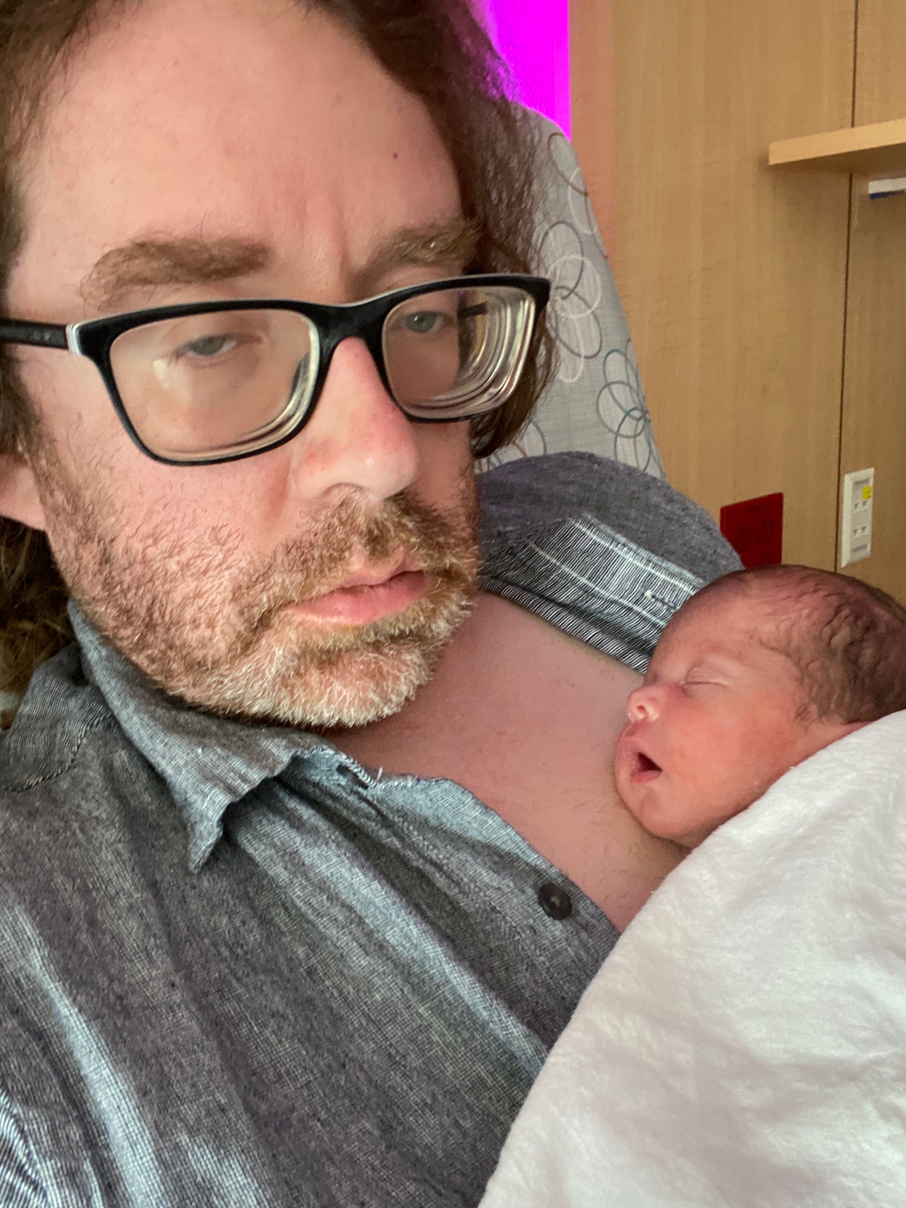 Dad holding his baby’s hand in the NICU